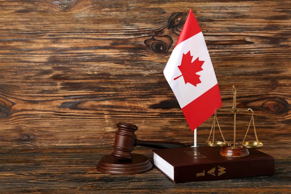 Murder & Homicide Defence Lawyers in Ottawa Ontario portrayed by a gavel, Canadian flag, legal book, & scales of justice.